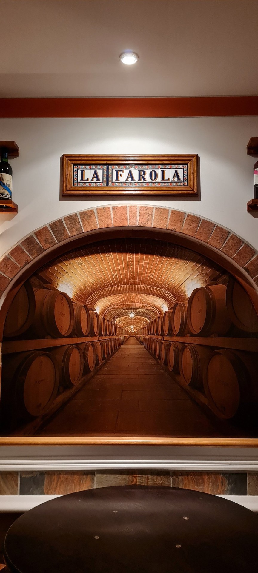 La Farola tiled sign above the wine cellar arch mural