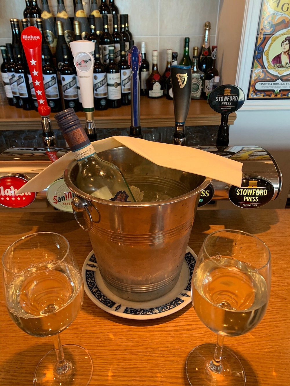 Chilled white wine in an ice bucket with Spanish beer taps behind